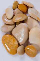 pebbles. clean white brown black pebbles isolated. the pebbles are on white or brown sand. small and large are visible