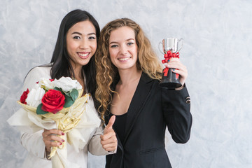 Leadership / employer management in company concept. Female Boss / manager giving reward cup, flower bouquet and bonus to best employee of the month to encouragement worker in the team