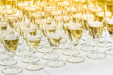 Many glasses of champagne on white table
