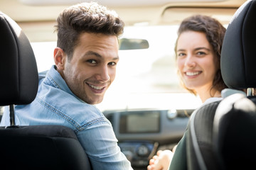 Couple traveling by car and smiling