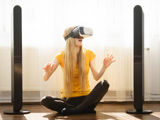 Girl wearing virtual reality goggles at home