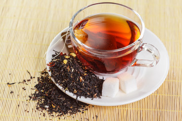 cup of black tea with mint leaves on a wooden table