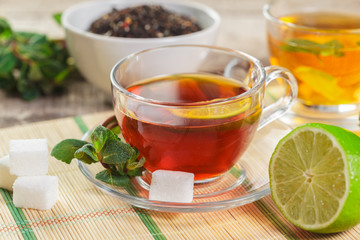 cup of black tea with mint leaves on a wooden table