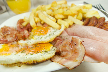 English breakfast - chips, egg, bacon, ham and sausages