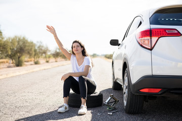 Woman with punctured car tyre looking for help © AntonioDiaz