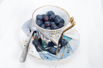 Sweet raw blueberries in old vintage cup with spoon