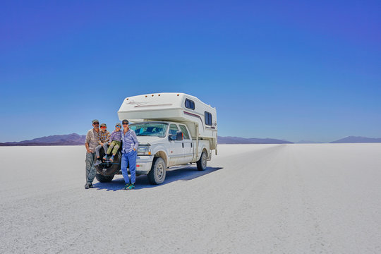 Portrait of family, standing in front of parked recreational vehicle, Salar de Uyuni, Uyuni, Oruro, Bolivia, South America