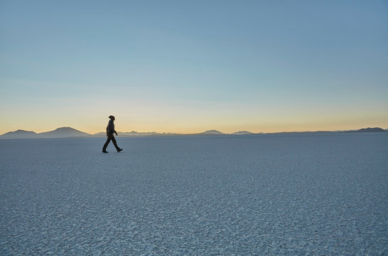 Woman walking across salt flats, Salar de Uyuni, Uyuni, Oruro, Bolivia, South America