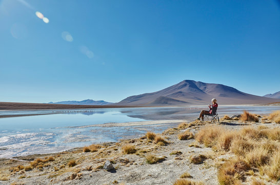 Woman sitting in camping chair, looking at view, Salar de Chalviri, Chalviri, Oruro, Bolivia, South America