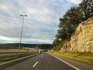 Empty Norwegian road near the rocky hill