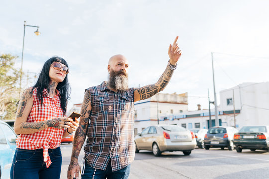 Mature hipster couple hailing a cab, Valencia, Spain