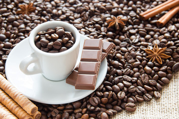 fried grains of coffee with a cup on a silver platter with chocolate and biscuits in a cup of coffee beans