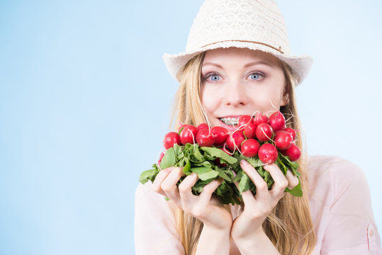 woman holding radish close to face