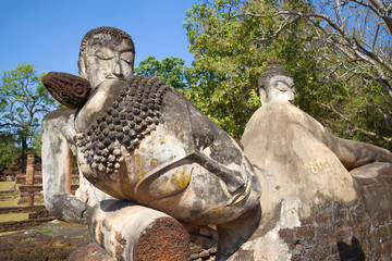Fototapeta na wymiar Head of the reclining Buddha close up. Ancient sculptures on the ruins of the temple Wat Phra Kaew. Kamphaeng Phet, Thailand