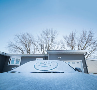 Smiley face drawn in snow on windscreen