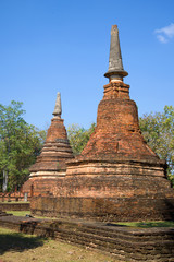 Fototapeta premium Two prangs on the ruins of the ancient Buddhist temple Wat Phra That. Kamphaeng Phet, Thailand