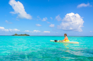 Fototapeta na wymiar Kayaking in tropical paradise - Canoe floating on transparent turquoise water, caribbean sea, Belize, Cayes islands