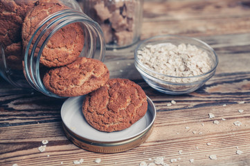 Oatmeal cookies with milk on tray on rustic wooden table