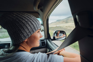 Young woman sitting in car, looking at view out of car window, Silverthorne, Colorado, USA