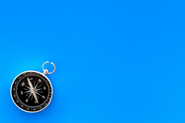 Compass on blue background top view copy space