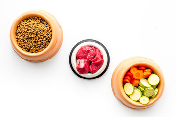 Ingredients for dry pet food. Meat and vegetables zucchini and carrot on white backgroud top view copy space