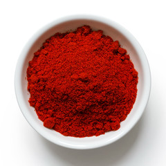 Paprika in white ceramic bowl isolated on white from above.