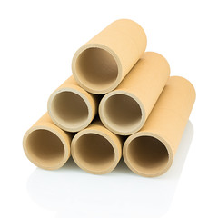A bunch of brown industrial paper core isolated on white background with shadow reflection. A lot of paper cores or paper tubes on white backdrop. Brown paper rolls.