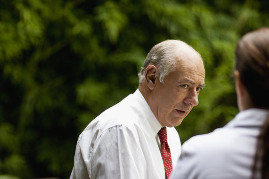 Serious looking businessman talking to a woman.