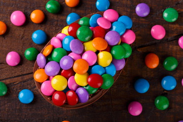 Obraz premium Chocolate egg with filling for Easter on wooden background