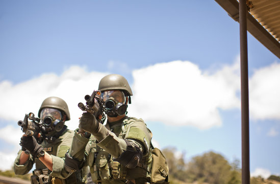Two police officers aiming guns at training facility