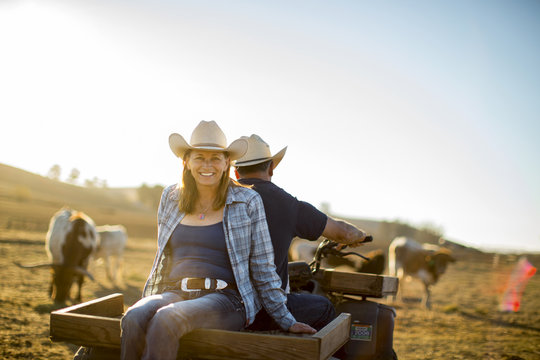 Portrait of a smiling woman sitting behind her husband on quad bike