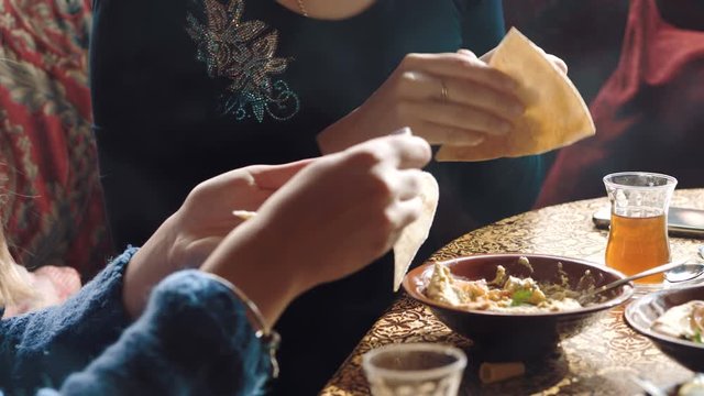 Young company is having fun and eating in bar. smoking a hookah, communicating in an oriental restaurant