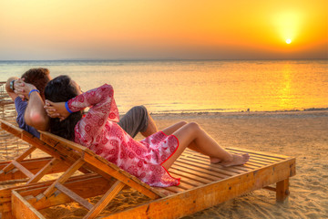 Couple watching sunrise on the beach of Red Sea in Egypt