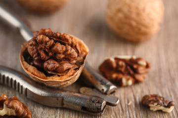Walnut kernels and whole walnuts on rustic old wooden table.