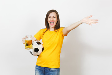 Beautiful European young cheerful woman, football fan or player in yellow uniform holding pint mug of beer, soccer ball isolated on white background. Sport, play football, healthy lifestyle concept.