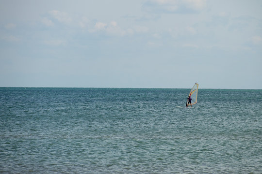 Windsurfing. Surfer exercising in calm sea or ocean.