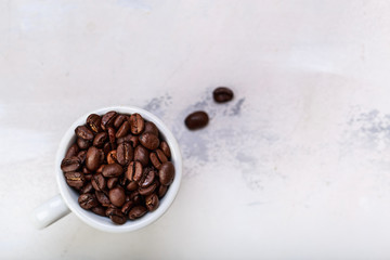 Coffee beans in white coffee cup brown white background