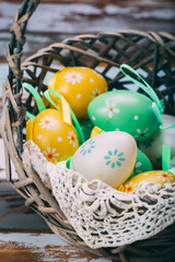 Easter eggs on wooden background colorful green yellow basket