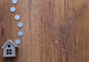 Real estate and mortgage . Wooden house and coins on the wooden background .