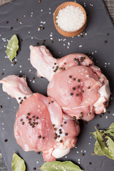 two turkey's shoulders, the upper part of the wing, raw meat, on black slate