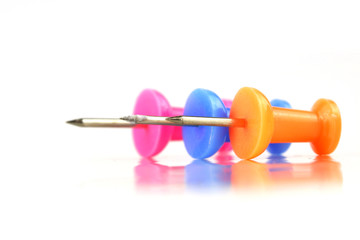 Three push pins against white background