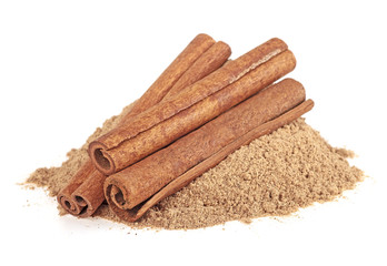 Three cinnamon sticks and powder, white background