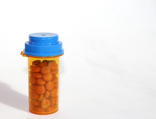 Orange medicine container with pills isolated on white background