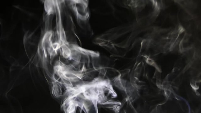 Beautiful gray smoke on a black background. Cigarette smoke. Smoke from the hookah. Turbulence of smoke. The white vapor rises. The smoke slowly flies.