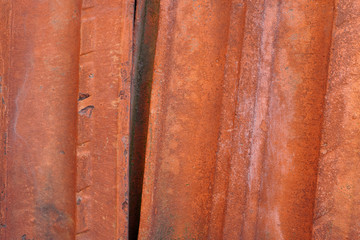 Old ceramic roof tiles abandoned on the pile and covered with mold. Shaggy texture, different colors, closeup.
