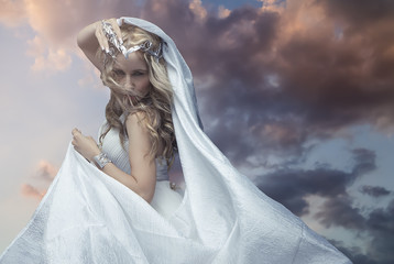Mythology, Greek goddess, blond woman with silver laurel wreath dressed in white silks in the wind....