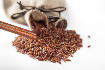 Wild red rice with sticks on white background