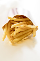 French fries in a box on a light background. Unhealthy food. Delicious food