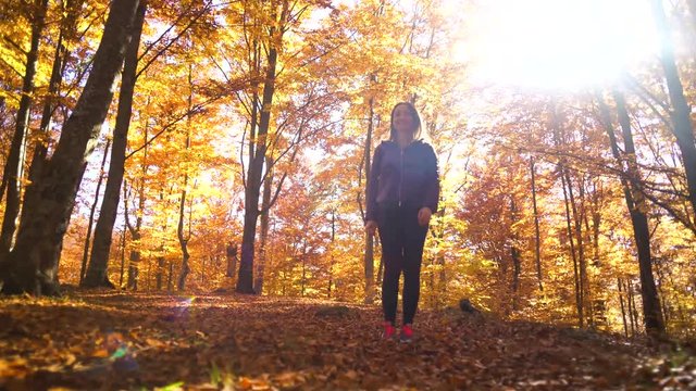 Happy young woman throwing leaves in a red forest