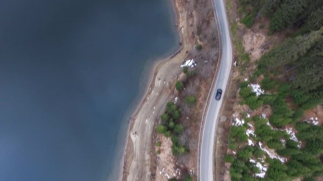 Aerial moving shot of a car driving on a mountain road